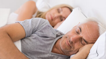 Senior man and woman sleeping. Senior man and woman resting with eyes closed. Mature couple sleeping together in their bed.