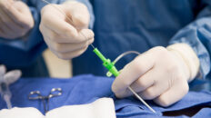 Hände eines Chirurgen mit beim Einführen eines Katheters