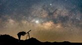 Silhouette of man watching star in telescope against milky way galaxy with stars and space dust in the universe.