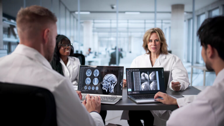 Neurologist At Hospital Analyzing Brain Scan On Computer Screen Carefully.